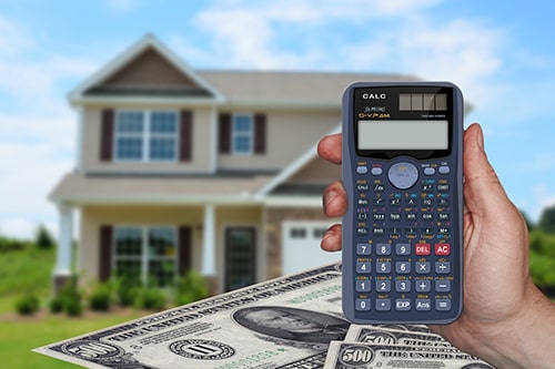 Calculator with house and money in background